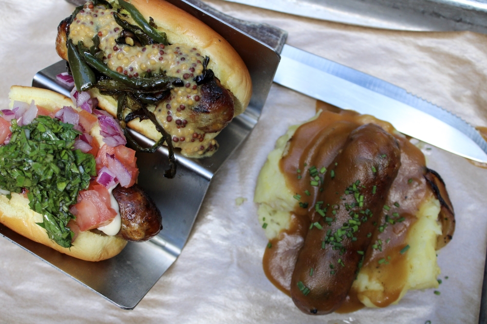 The Sausage Sampler includes a rotating selection of three mini sausages in buns and fully dressed. The rotation selection includes the pictured sausages: the Jalapeño Cheddar Bratwurst, the Spanish Style Chorizo and Banger & Mash. (Dacia Garcia/Community Impact)