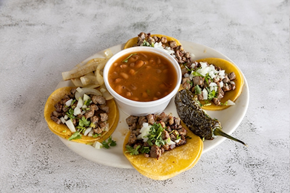 Pollo Picosito's mini tacos plate ($11) is dished out street style with beans, onions and cilantro on top. (Courtesy Pollo Picosito)