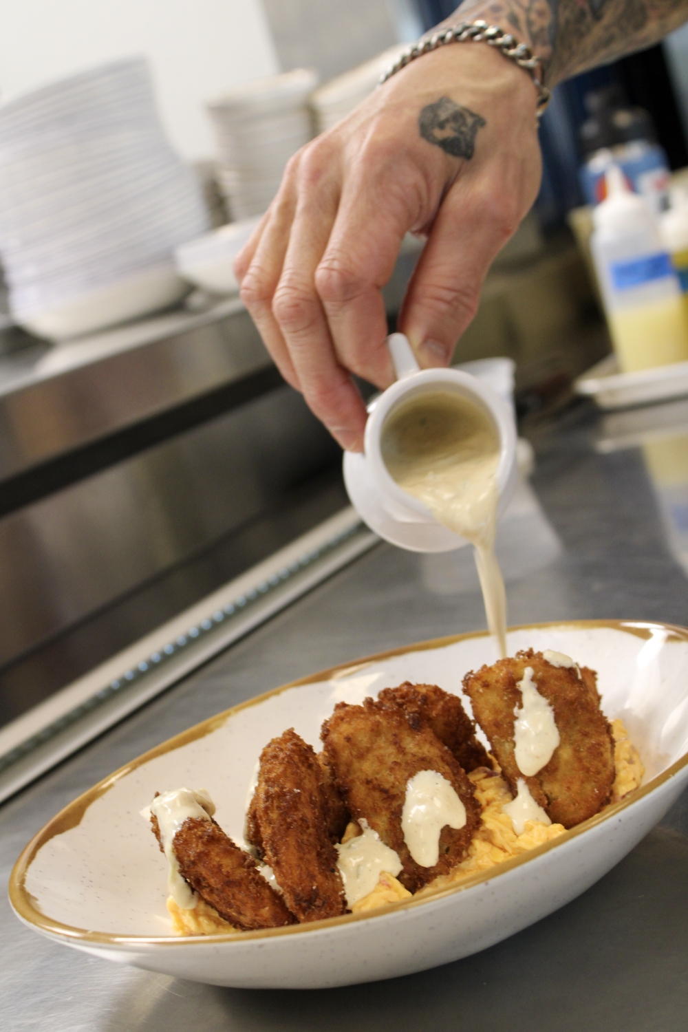 Diners can enjoy a range of appetizer options including Fried Green Tomatoes served with pimento cheese and white barbecue sauce. (Dacia Garcia/Community Impact)