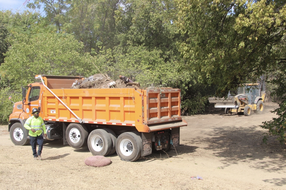 Crews cleared debris from an encampment off West Cesar Chavez Street Oct. 21. (Ben Thompson/Community Impact)