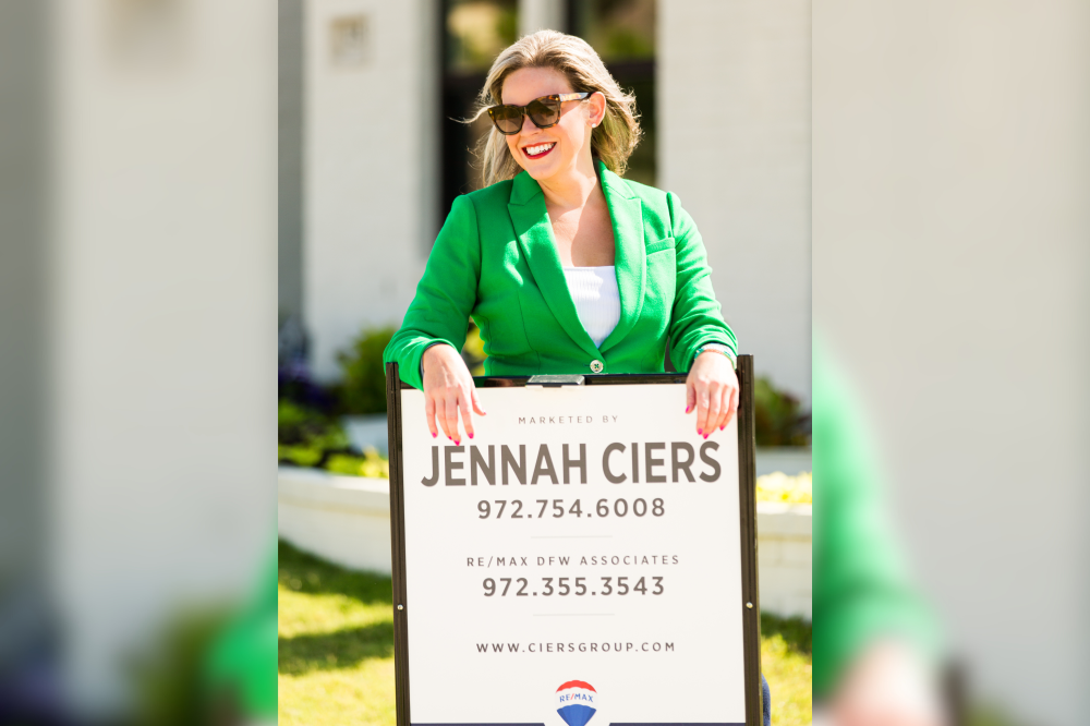 Realtor in DTX posing with sign