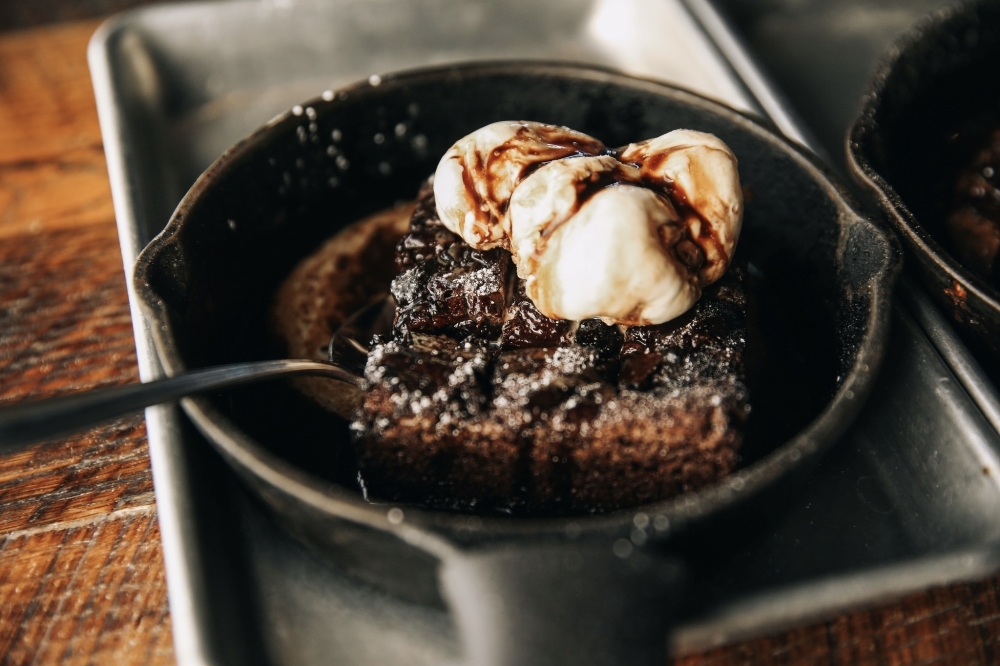 The restaurant offers desserts such as the warm brownie, which is topped with vanilla ice cream and chocolate syrup. (Courtesy Crust Pizza via Facebook)