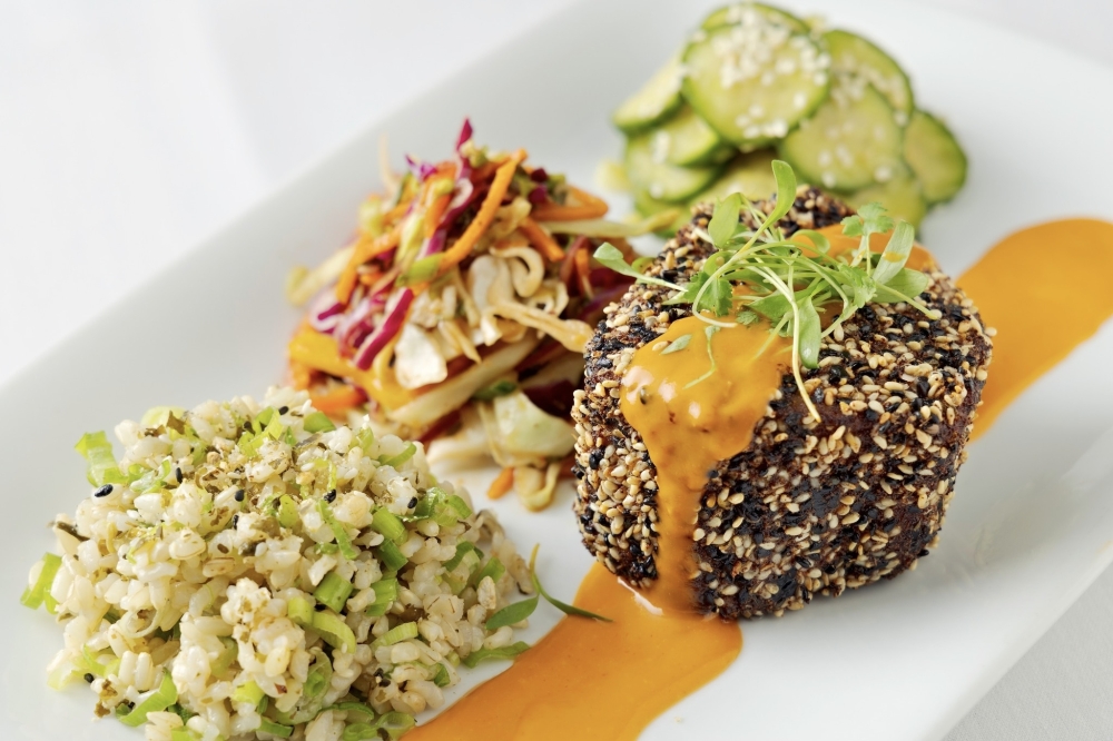Perry's Ahi Tuna Fillet Mignon is topped with miso umami butter and served alongside pickled cucumbers, furikake rice, and a colorful rainbow slaw. (Courtesy Perry's Steakhouse & Grille)