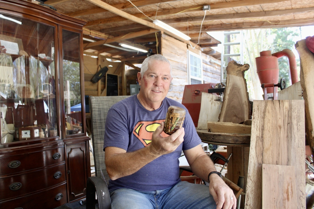 Chosen Farm and Sawmill owner, Joey Jamison holds a cup made with wood and resin. (Jovanna Aguilar/Community Impact)