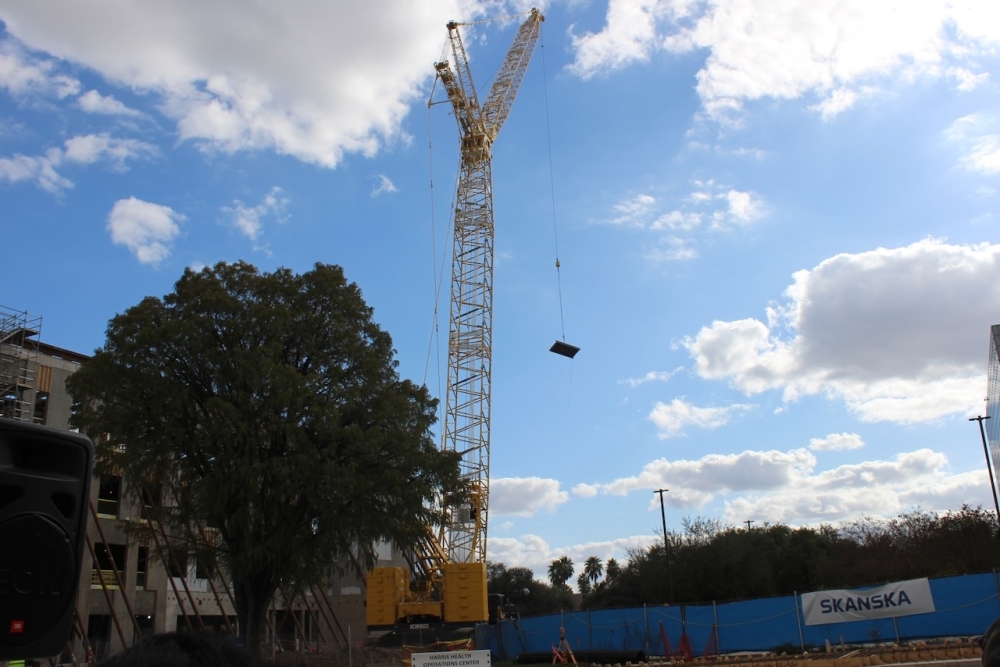 A beam is moved across the construction site where Harris Health will open its new operation center in the Texas Medical Center. (Melissa Enaje/Community Impact)