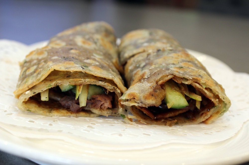 Braised beef wrap ($14) featured braised beef wrapped in a scallion pancake and brushed with savory soy glaze. (Karen Chaney/Community Impact)