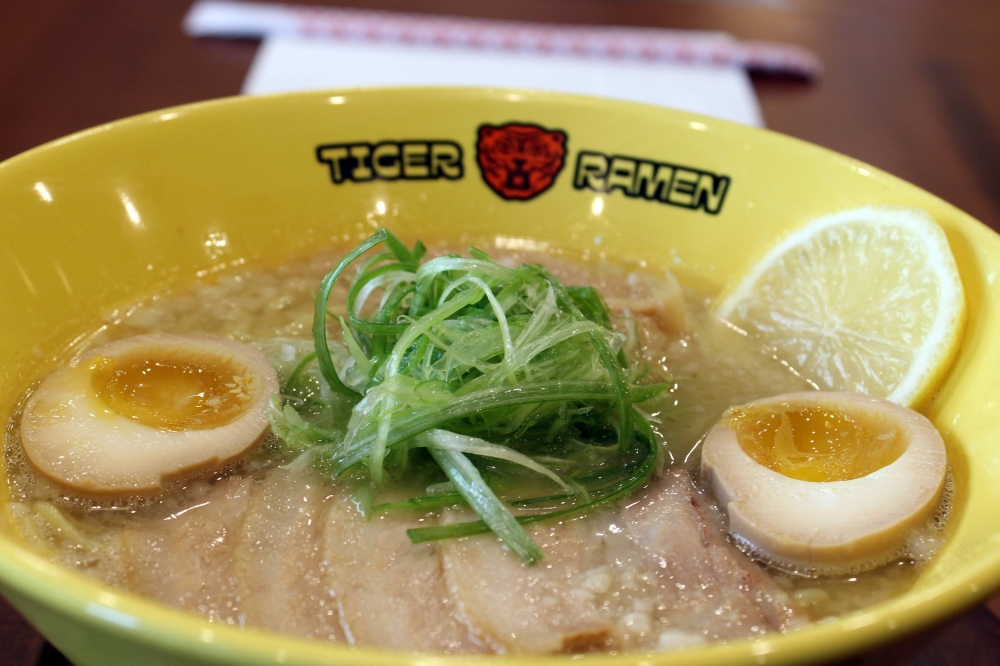 Paitan ramen ($15.99) features chicken tonkotsu broth topped with pork chashu, nitamago, scallion, menma and lemon. (Karen Chaney/Community Impact)
