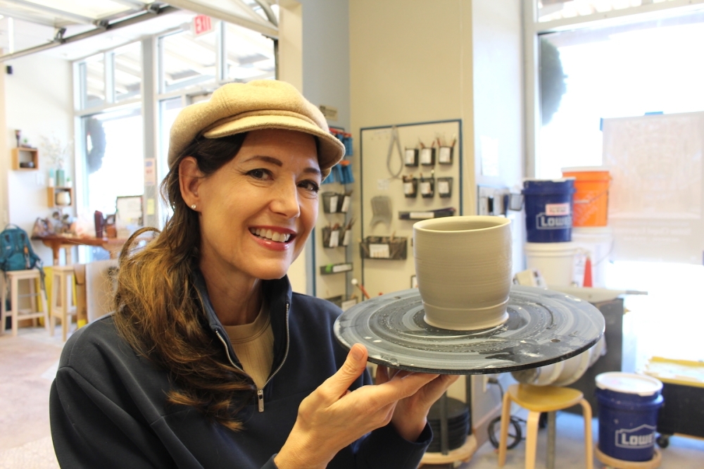 Owner Jules Winson poses with a piece that she crafted. (Sienna Wight/Community Impact