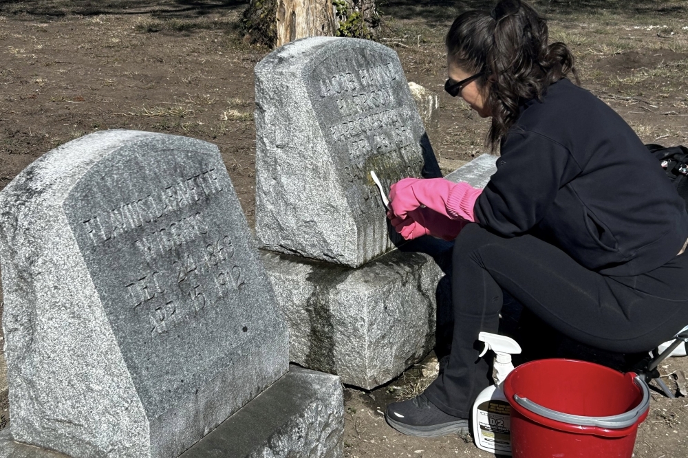 A volunteer cleaning grave markers as part of the the Cemetery Stewardship Program. (Courtesy San Antonio Parks and Recreation Department)