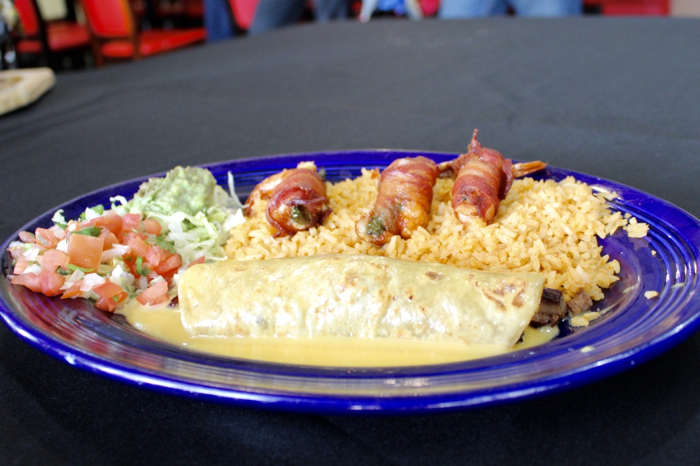 The Taco Diablo includes Spanish rice, a beef taco smothered in cheese and three shrimp wrapped in bacon and paired with pico de gallo and guacamole. (Jovanna Aguilar/Community Impact)