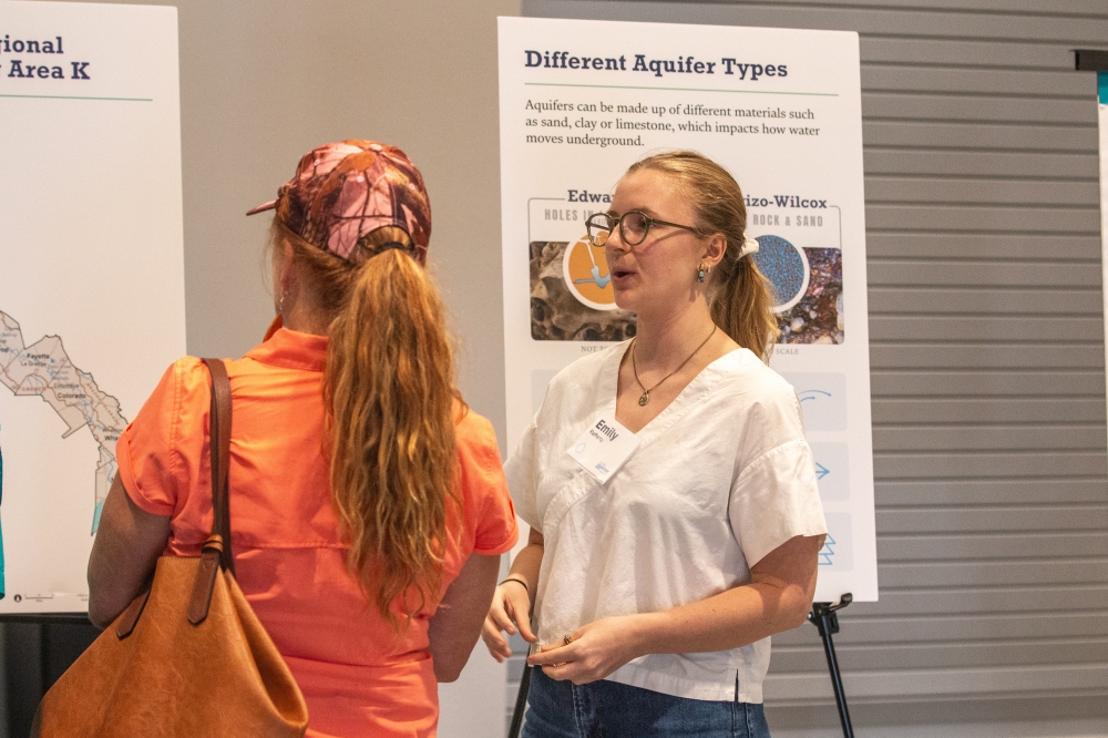 Emily Rafferty, an Austin Water staff member, discusses Austin’s planned Aquifer Storage and Recovery project with a Bastrop-area resident during an open house at the Community Center in Mayfest Park on Sept. 3. (Joel Valley/Community Impact)